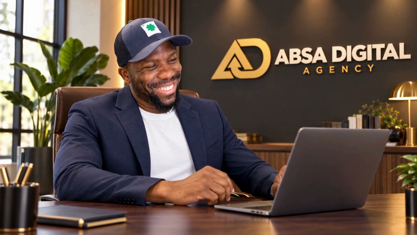 Adama Diouf at his desk beside the Absa Digital Agency branding